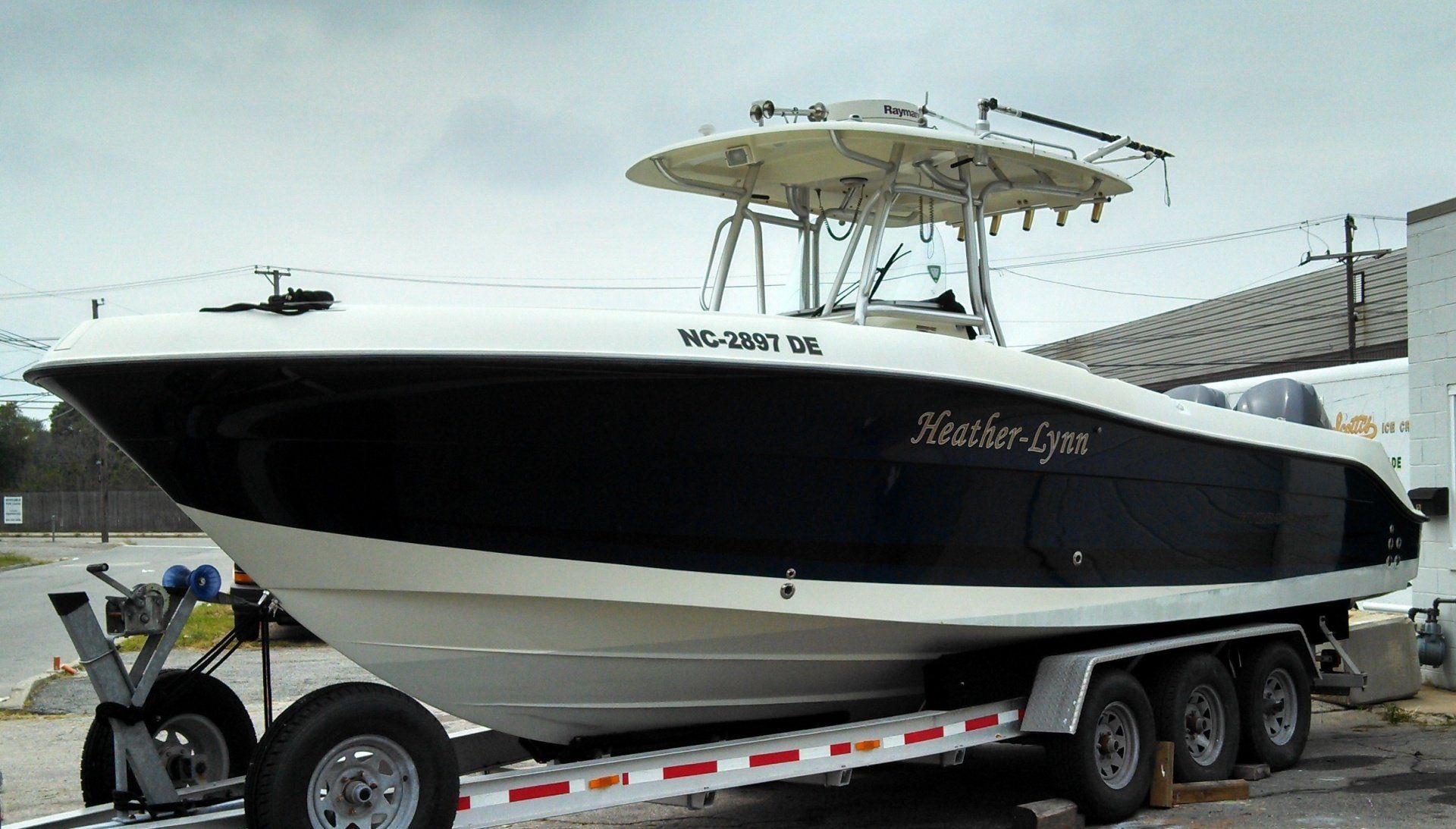 A white and black boat on a trailer with a roof