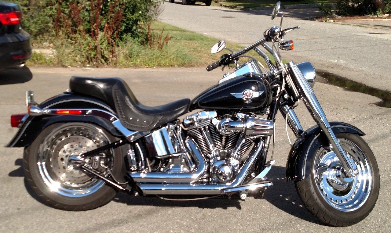 A black harley davidson motorcycle is parked on the side of the road