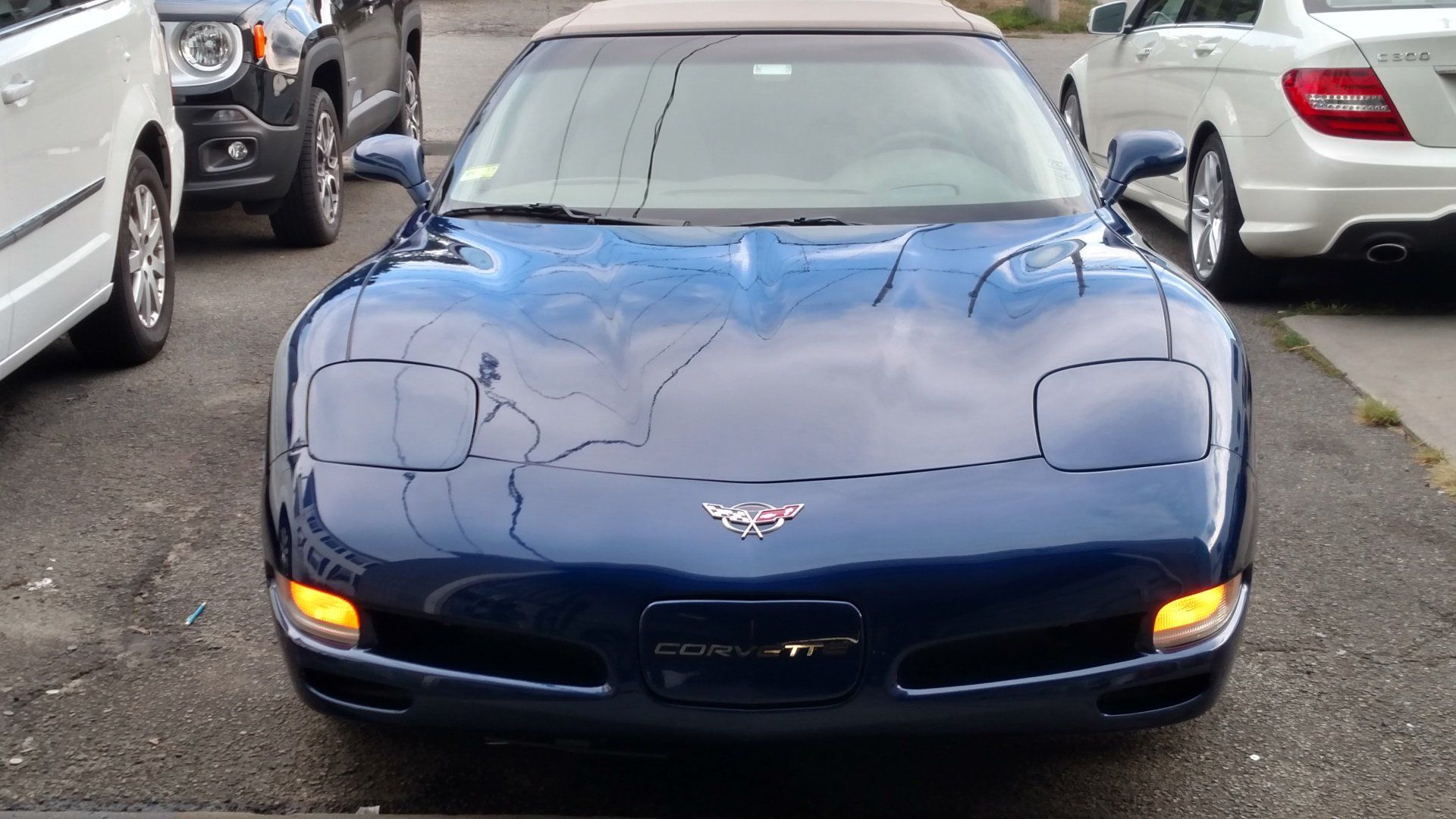 A blue sports car is parked in a parking lot