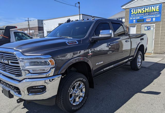 A gray ram truck is parked in front of a building.