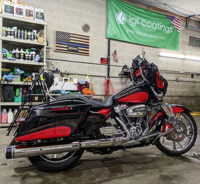 A black and red harley davidson motorcycle is parked in a garage.