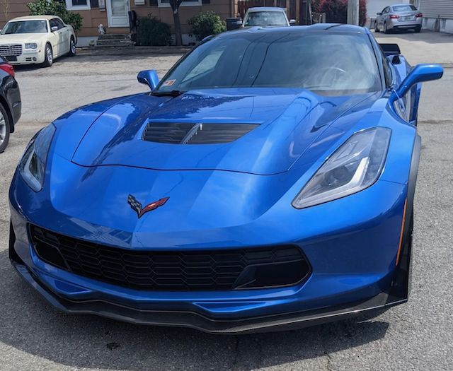 A blue corvette is parked in a parking lot