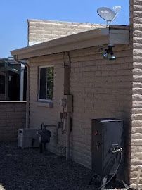 A brick house with a satellite dish on the roof.