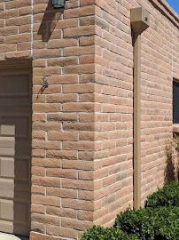 A brick building with a garage door and a window.
