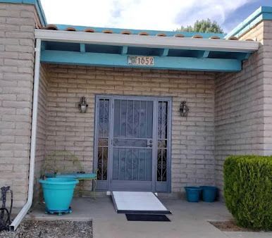 A brick house with a blue roof and a blue door