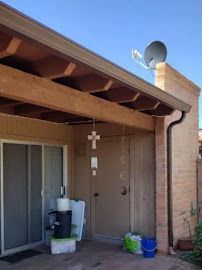 A house with a sliding glass door and a satellite dish on top of it.