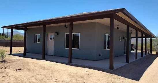 A house with a porch and a blue sky in the background