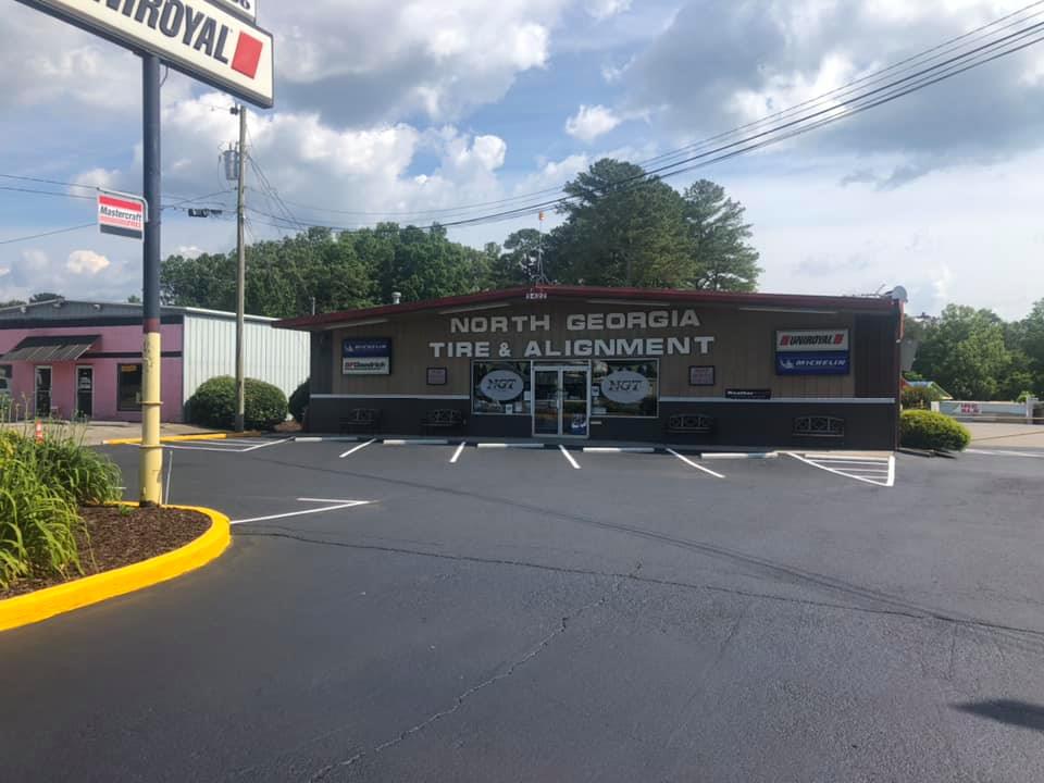 A tire and alignment shop in north georgia with a parking lot in front of it.