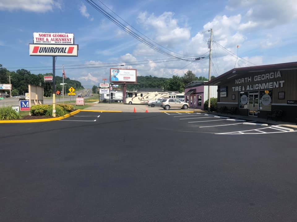 A parking lot with cars parked in front of a building.