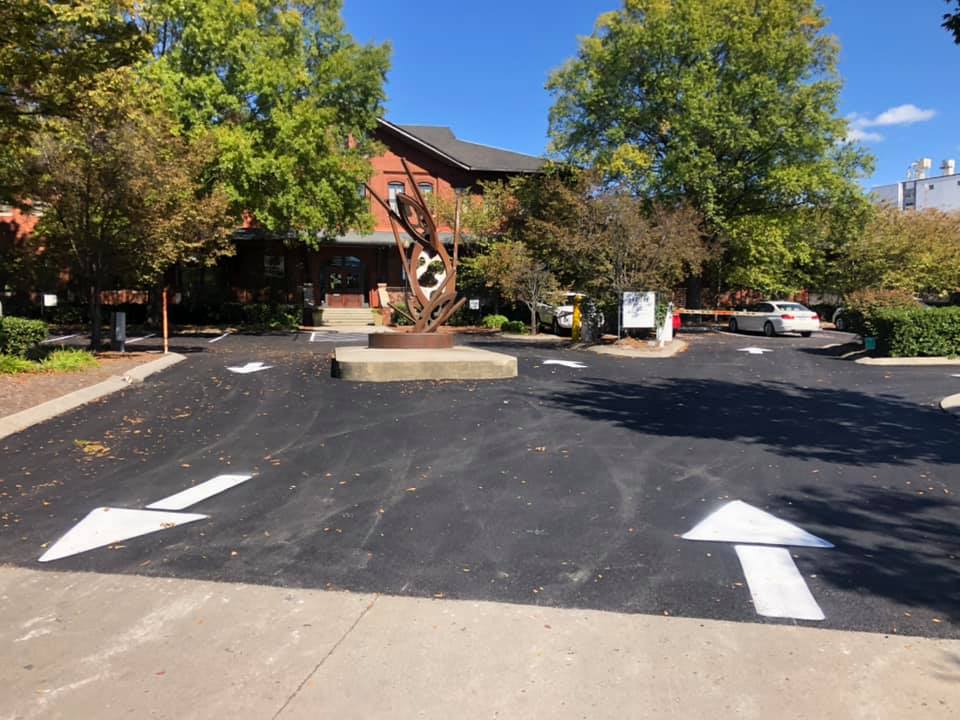 A parking lot with arrows painted on it in front of a building.
