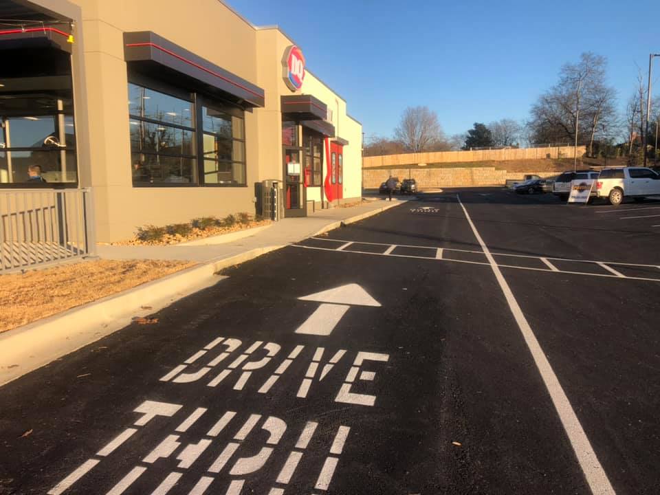 A drive thru sign is painted on the side of the road