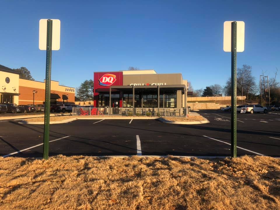 A dq restaurant with a parking lot in front of it