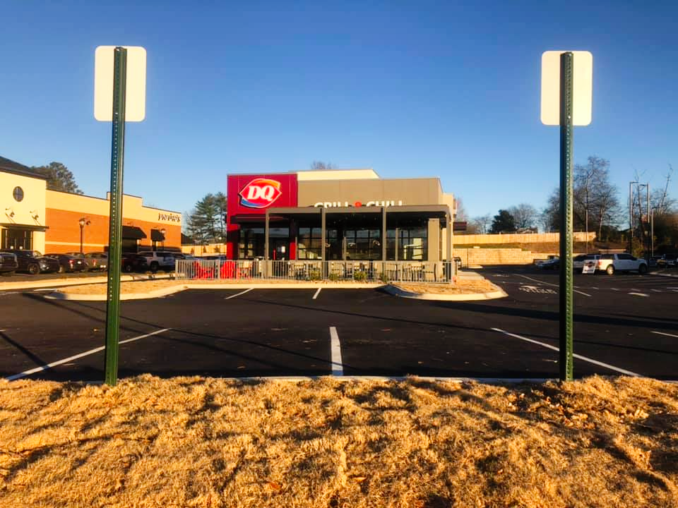 A dq restaurant with a parking lot in front of it