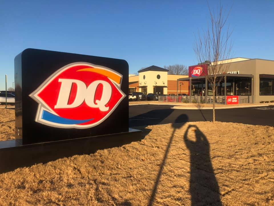 A large dq sign is in front of a building
