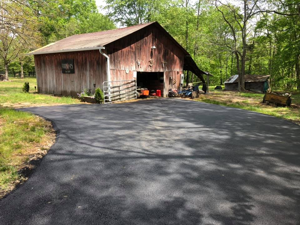 A red barn is sitting in the middle of a lush green field.