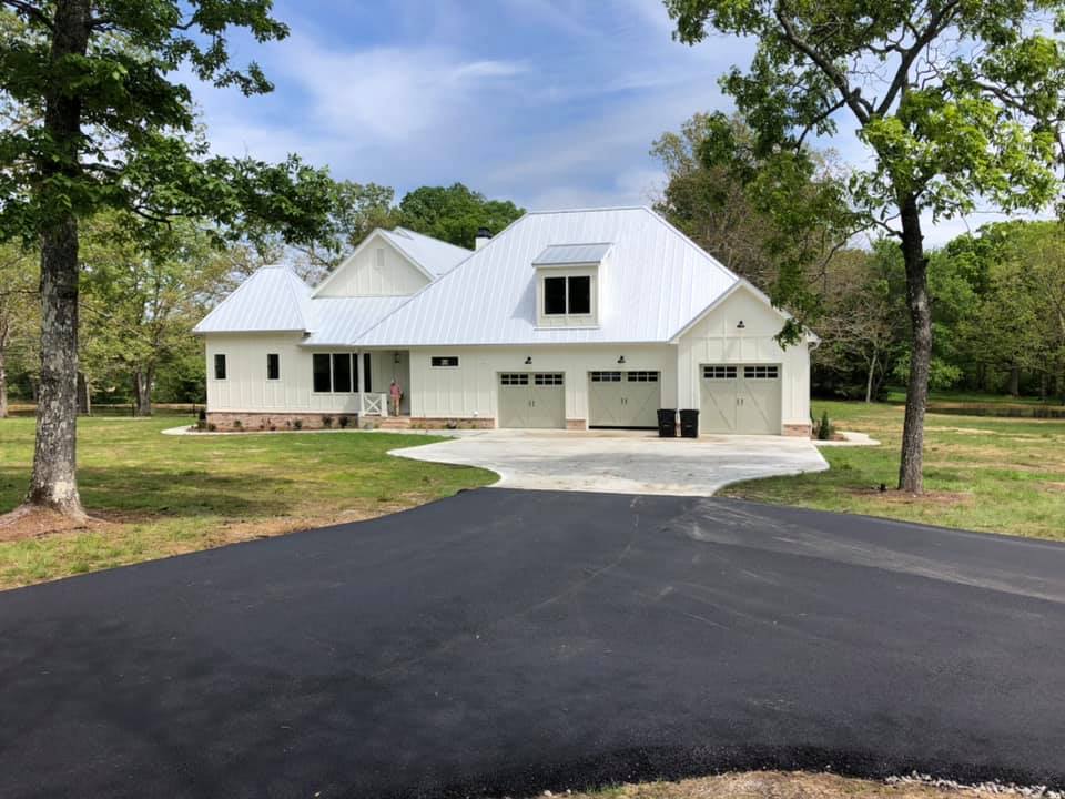 A large white house with a driveway leading to it
