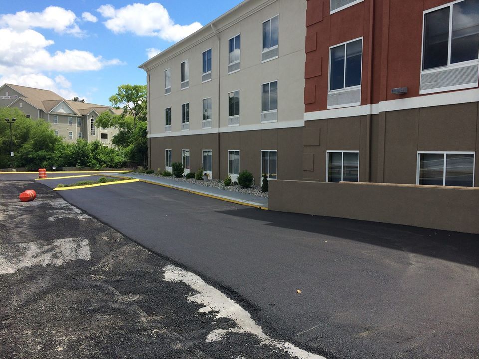 A building with a lot of windows and a parking lot in front of it