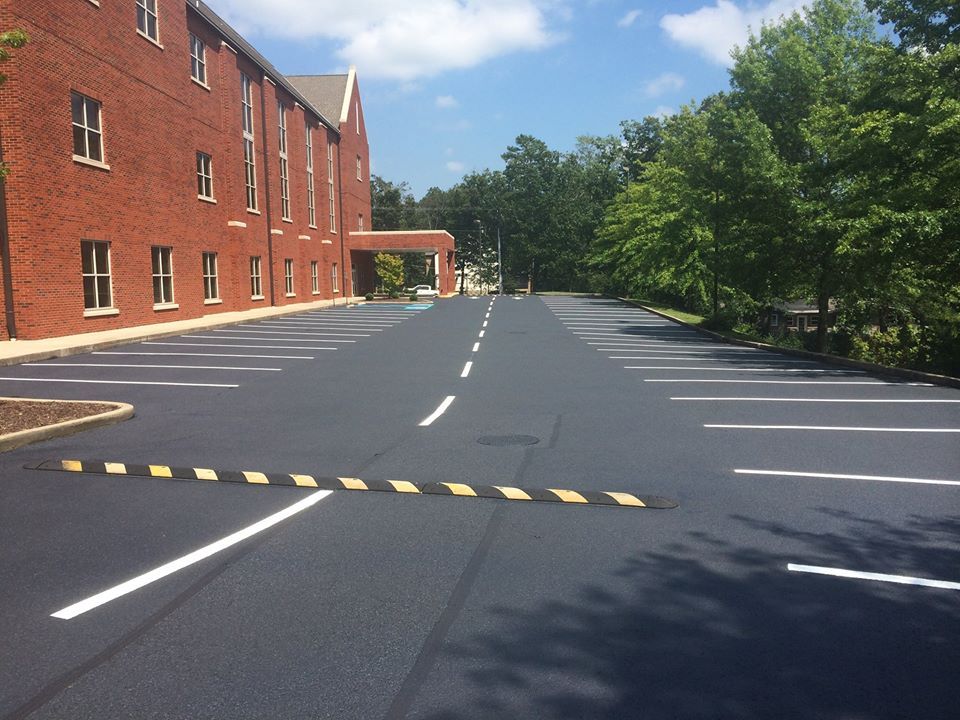 A parking lot with a brick building in the background