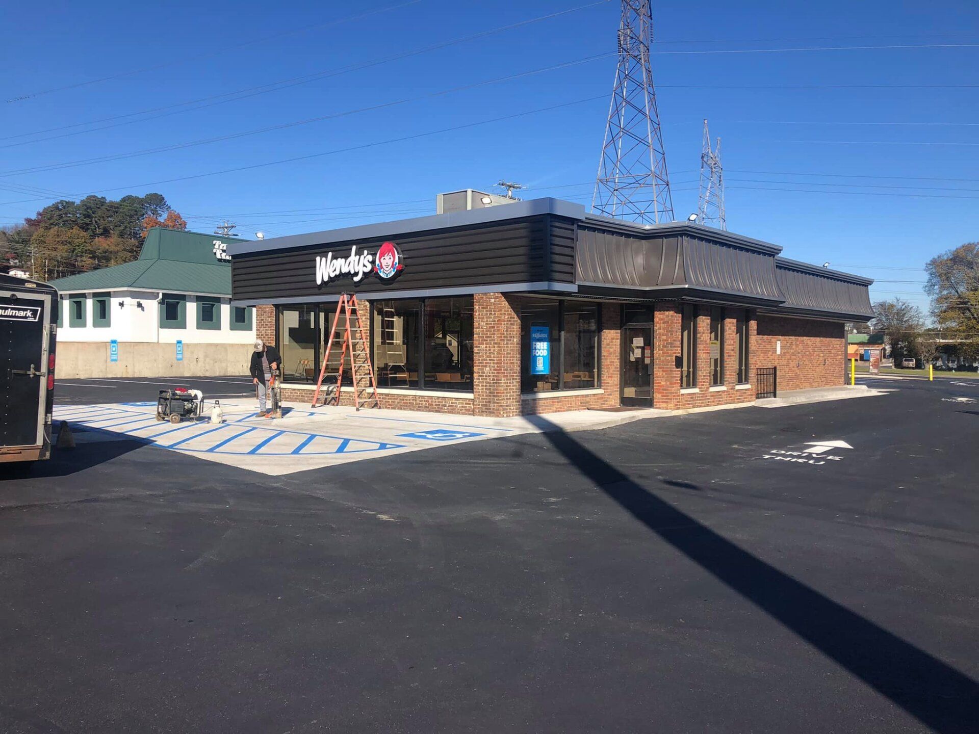 A wendy 's restaurant is being built in a parking lot.