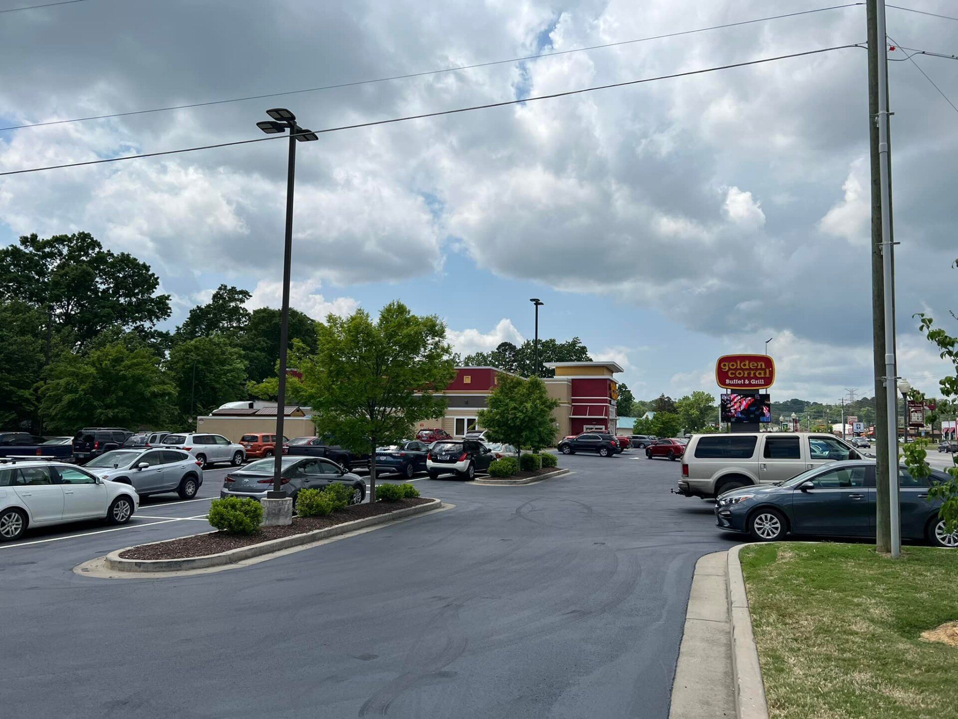 A lot of cars are parked in a parking lot in front of a restaurant.