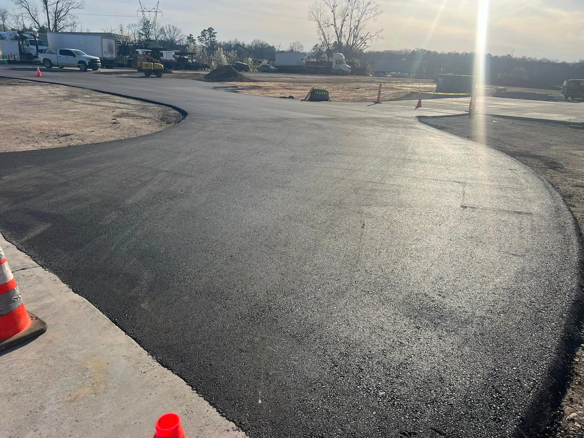 A newly paved road is being built in a parking lot.