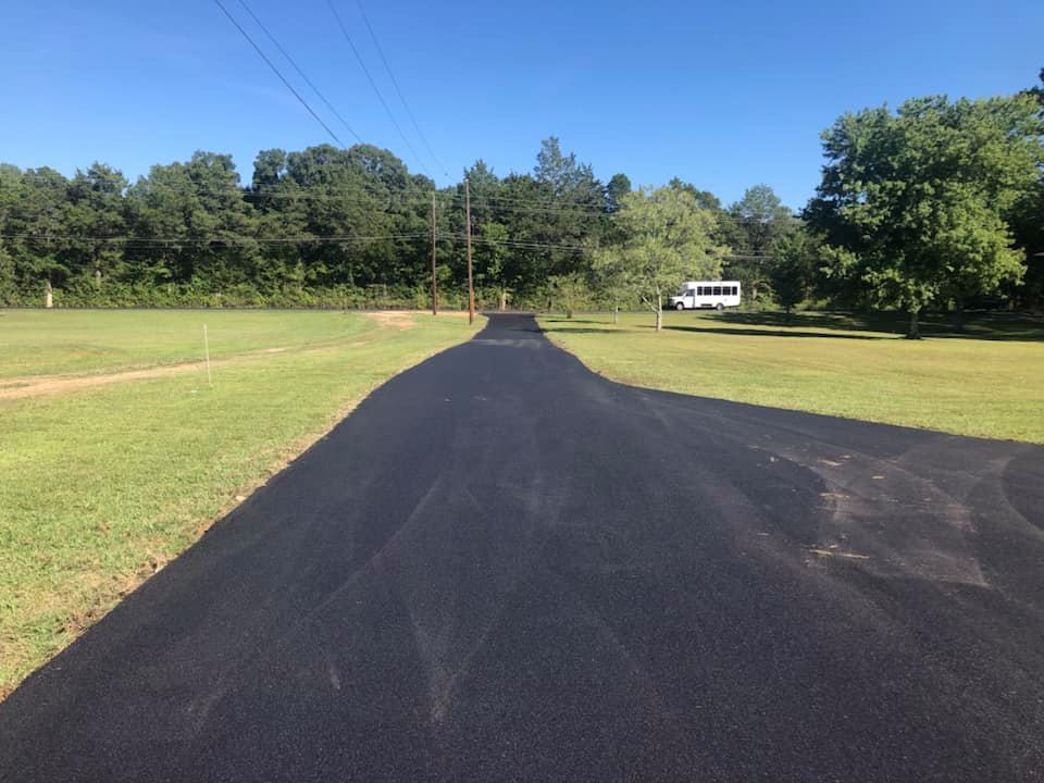 A road that is going through a grassy field