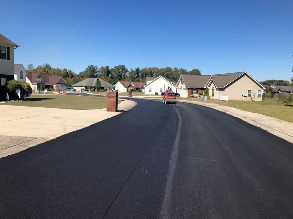 A car is driving down a road in a residential neighborhood.