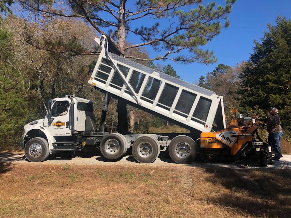 A dump truck is parked on the side of a road.