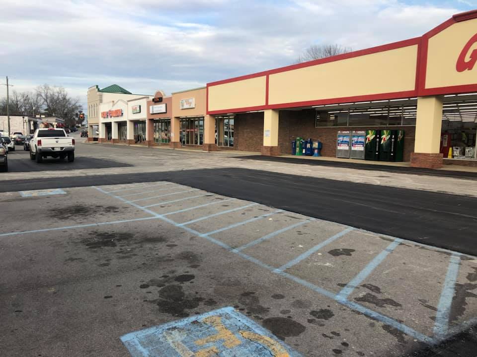 A parking lot with a handicapped parking spot in front of a store.