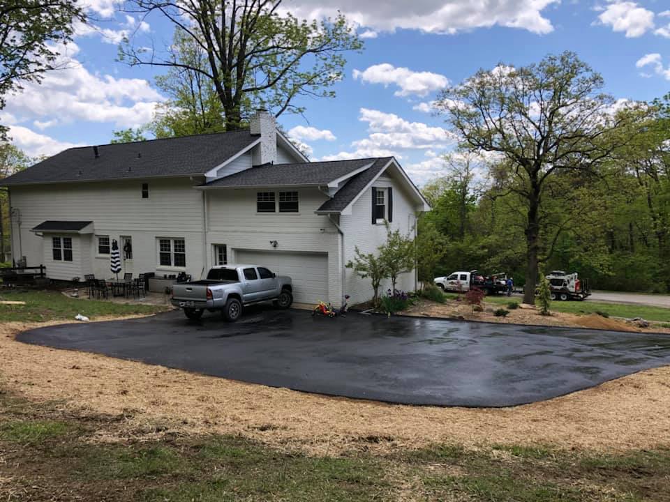 A white house with a truck parked in front of it.