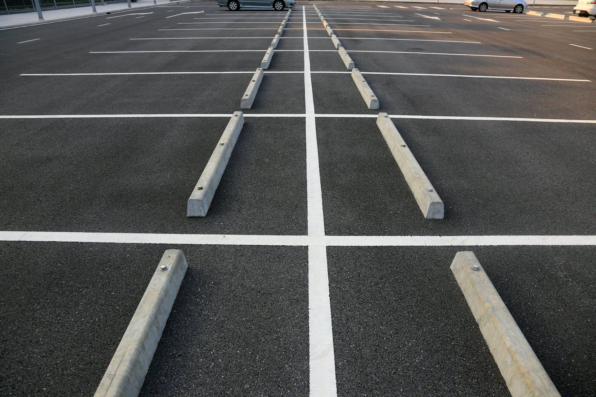 A parking lot with concrete curbs and white lines