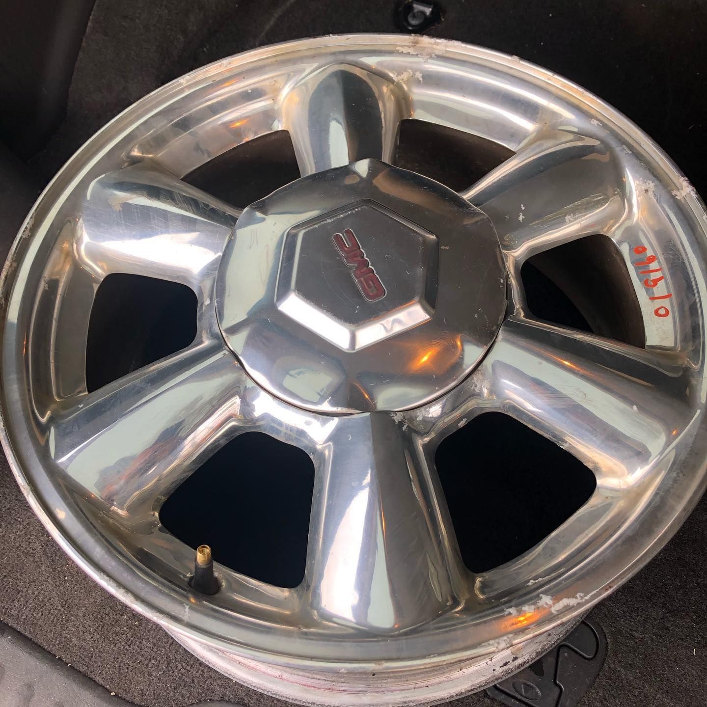 Silver alloy car wheel with a Lincoln emblem, possibly from a vehicle's hubcap.