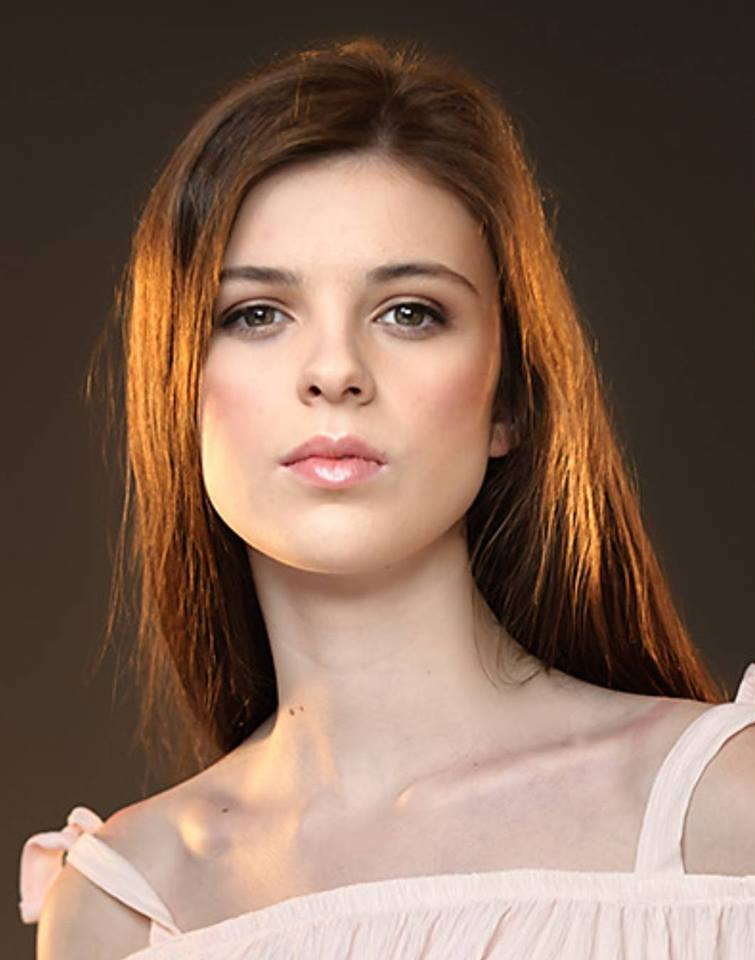 Ginger woman pouting as she looks down at camera