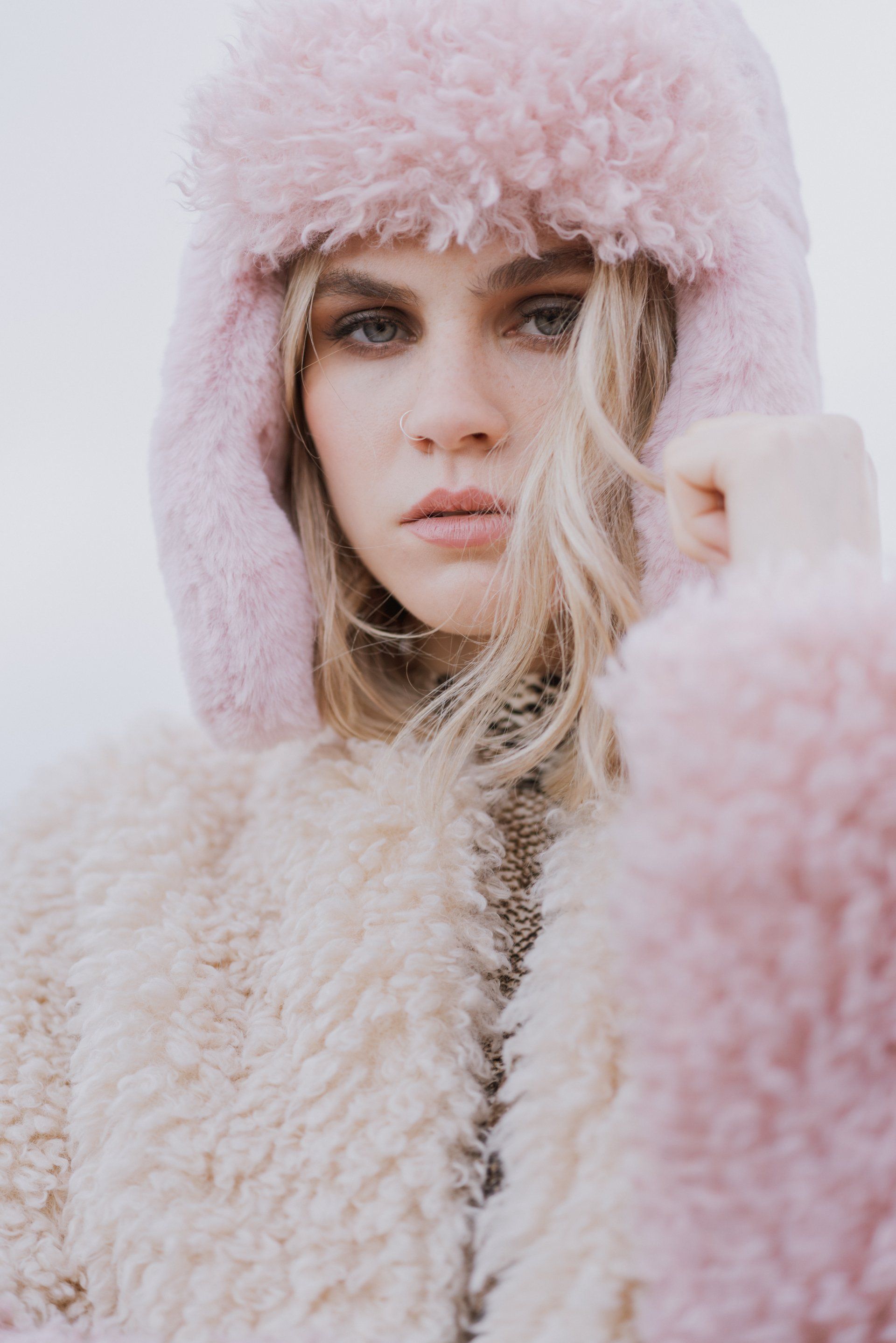 Woman with blonde hair wearing pink fluffy hoodie
