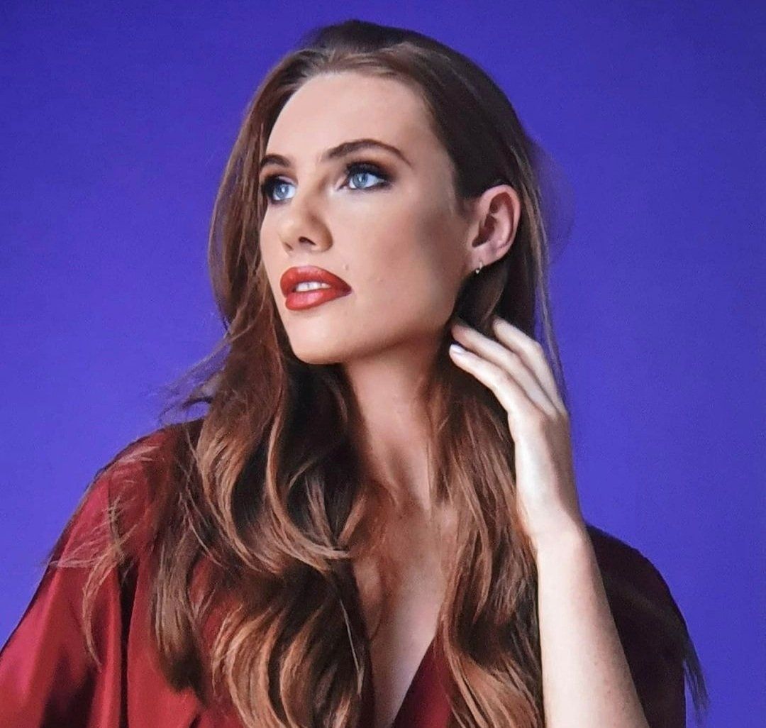 Blue background with woman looking away from camera as if intrigued