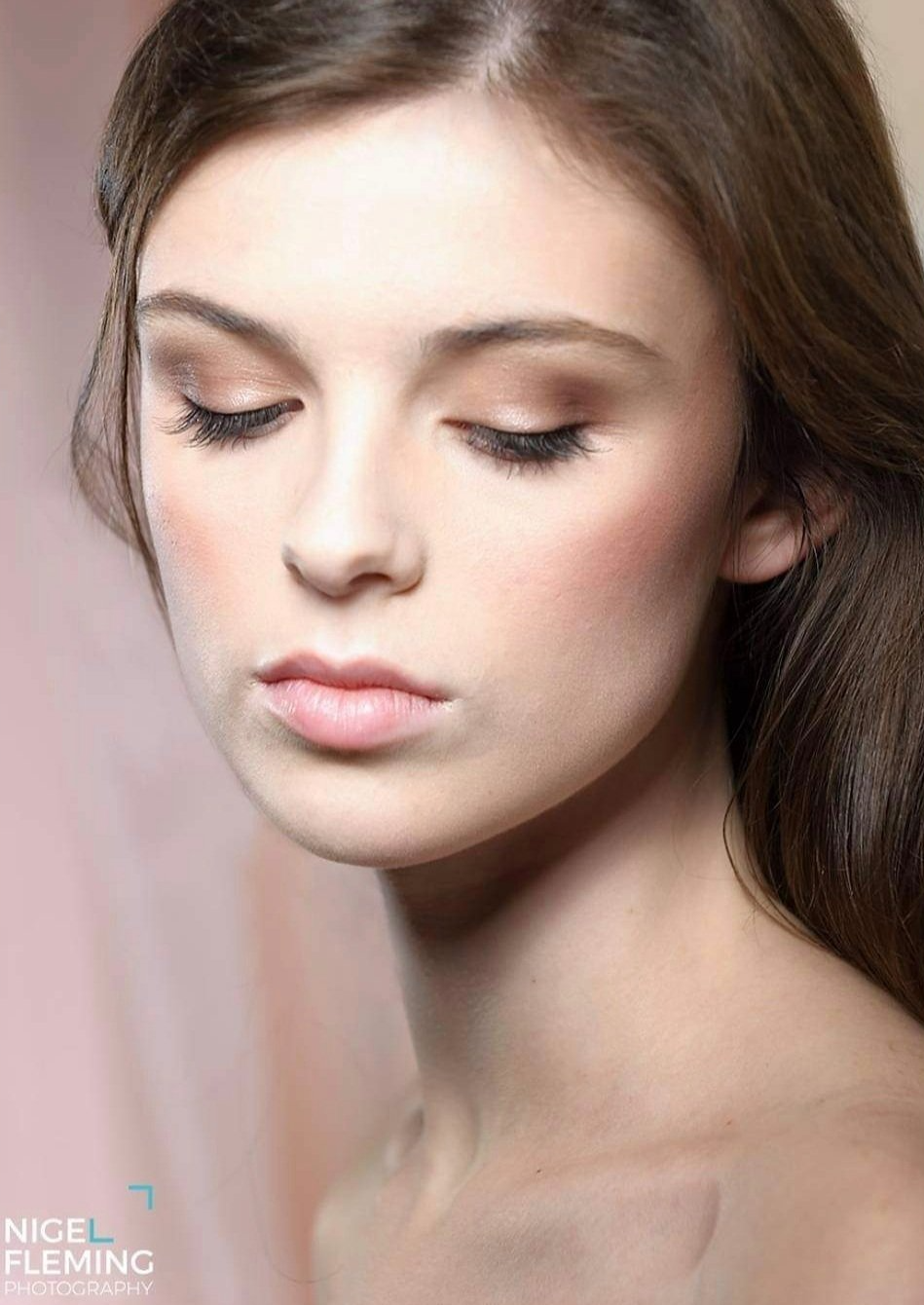 Close-up of young woman with natural make-up looking down