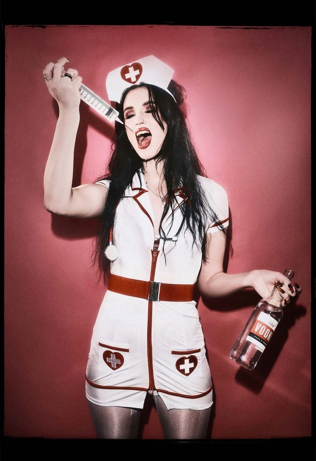 Woman dressed as nurse drinking vodka