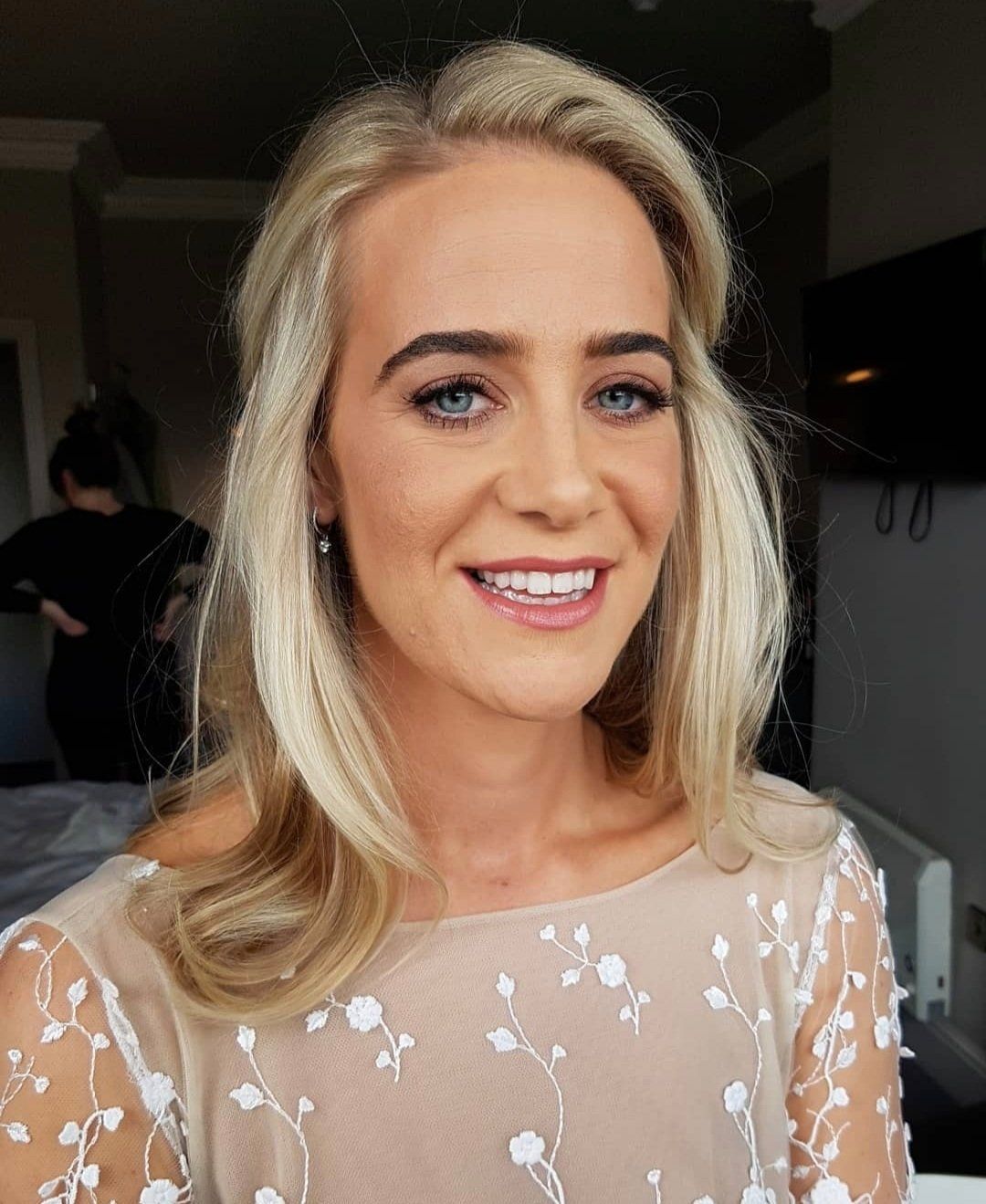 Blonde women with pink dress, smiling at camera