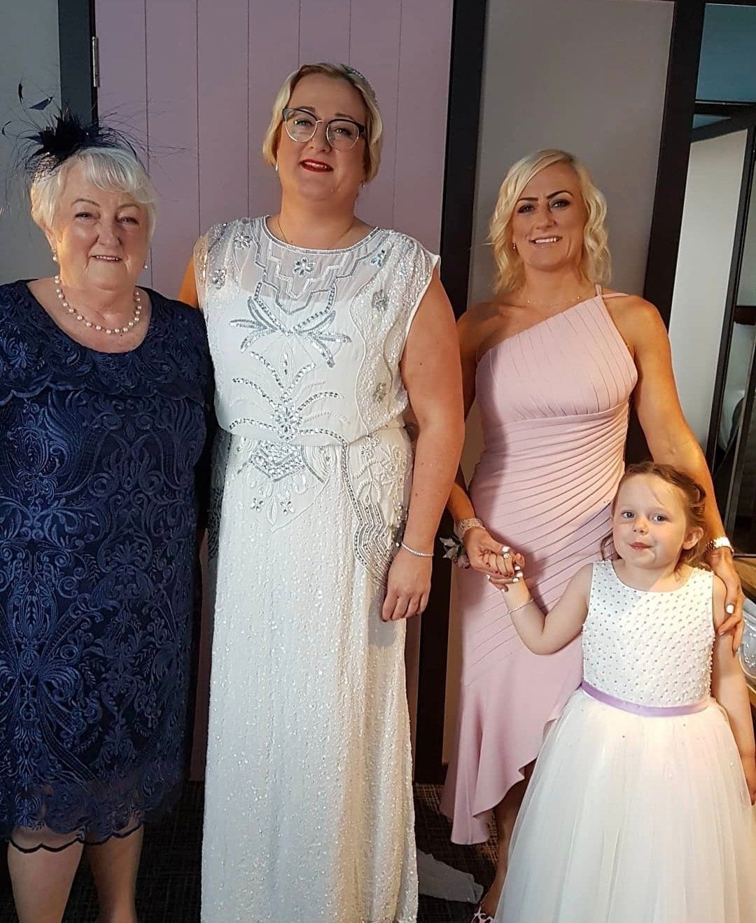 Bride stood with wedding guests smiling for camera