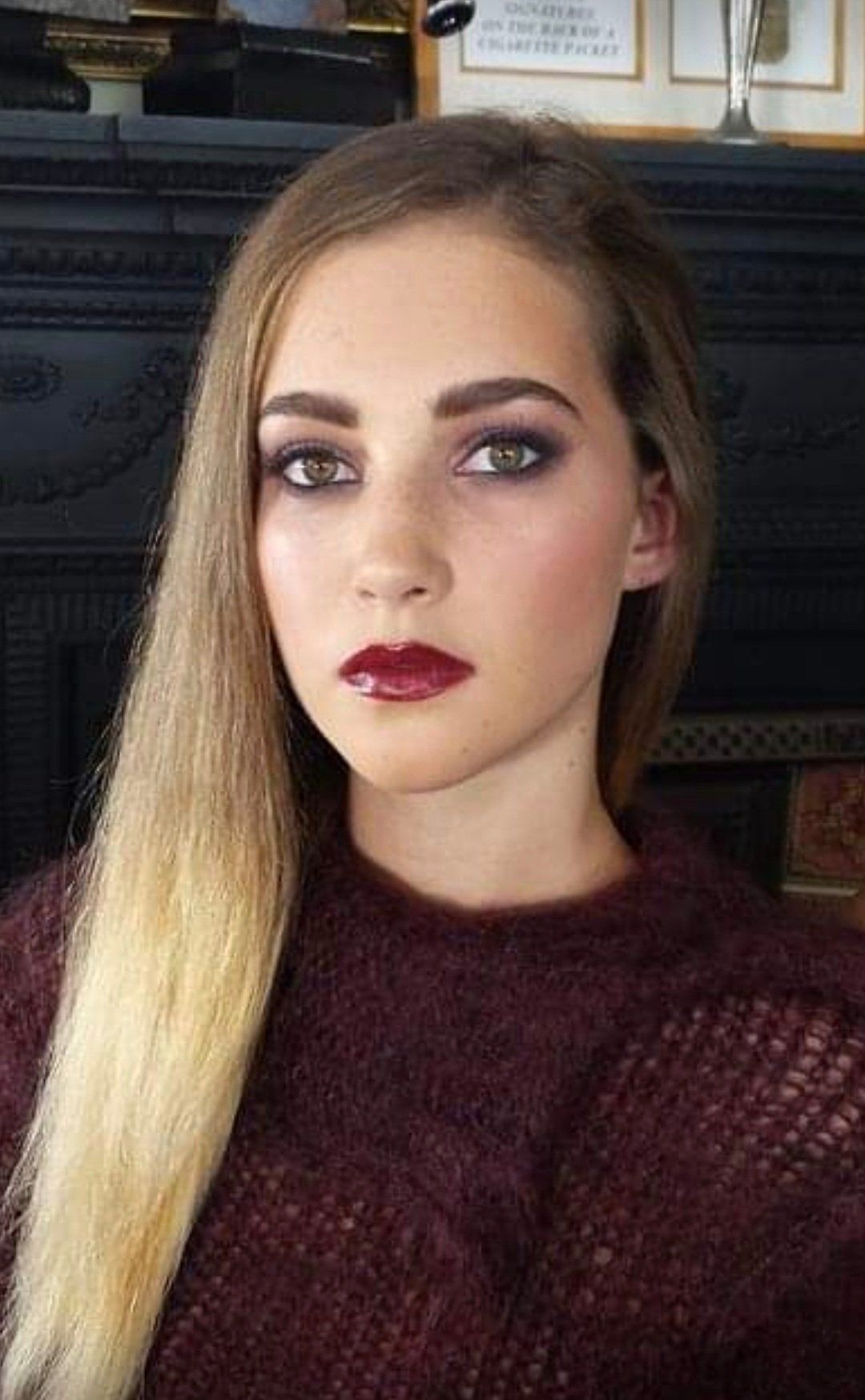 Blonde woman looking serious with red lips, looking directly at camera