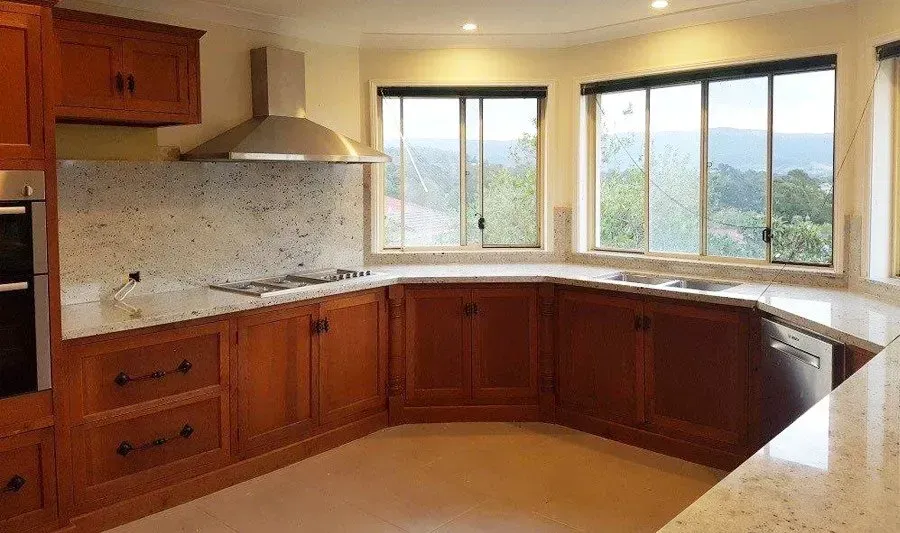 Corner Countertop With Wooden Cabinets — Wollongong, NSW — Superior Stone