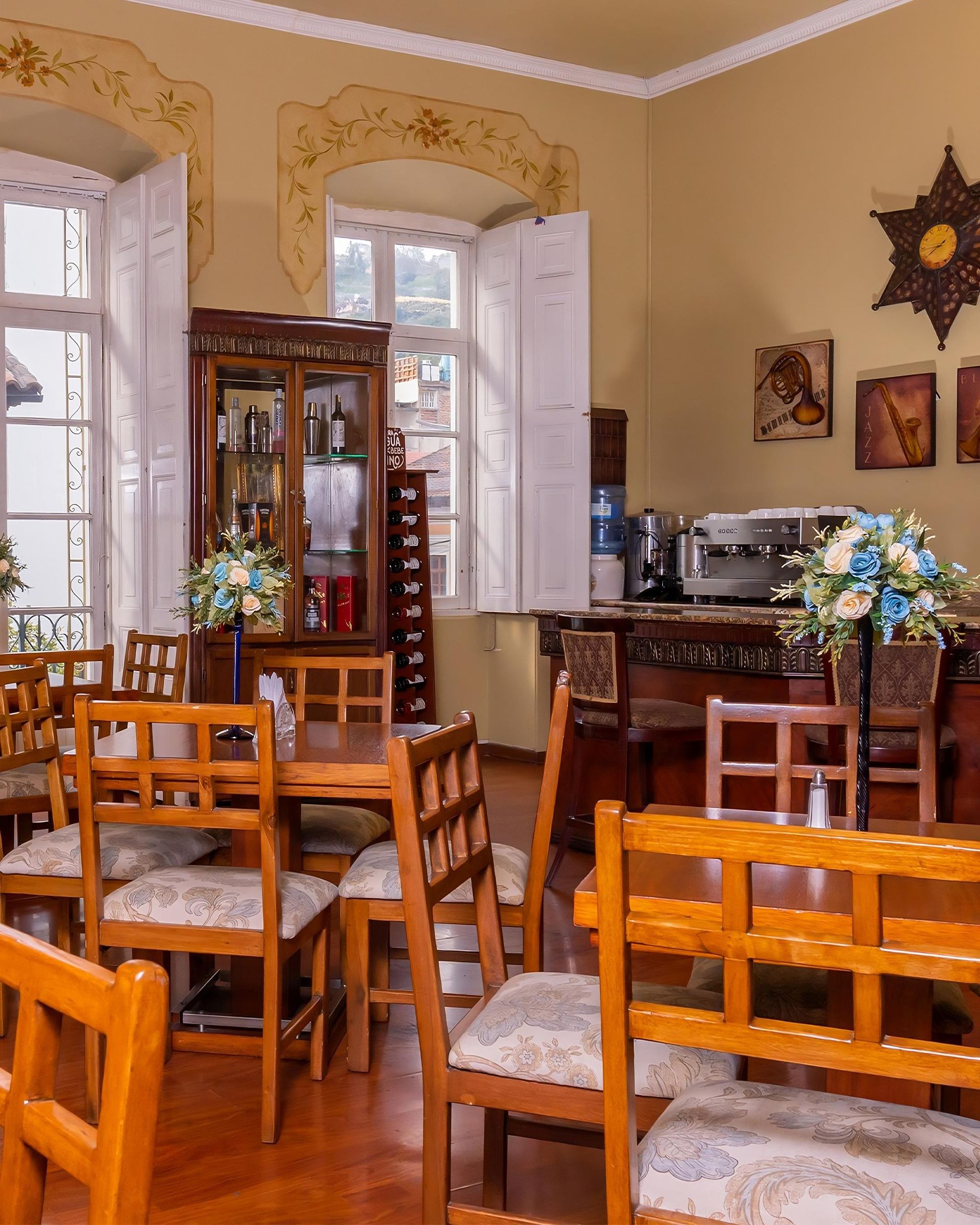 A dining room with tables and chairs and a clock on the wall