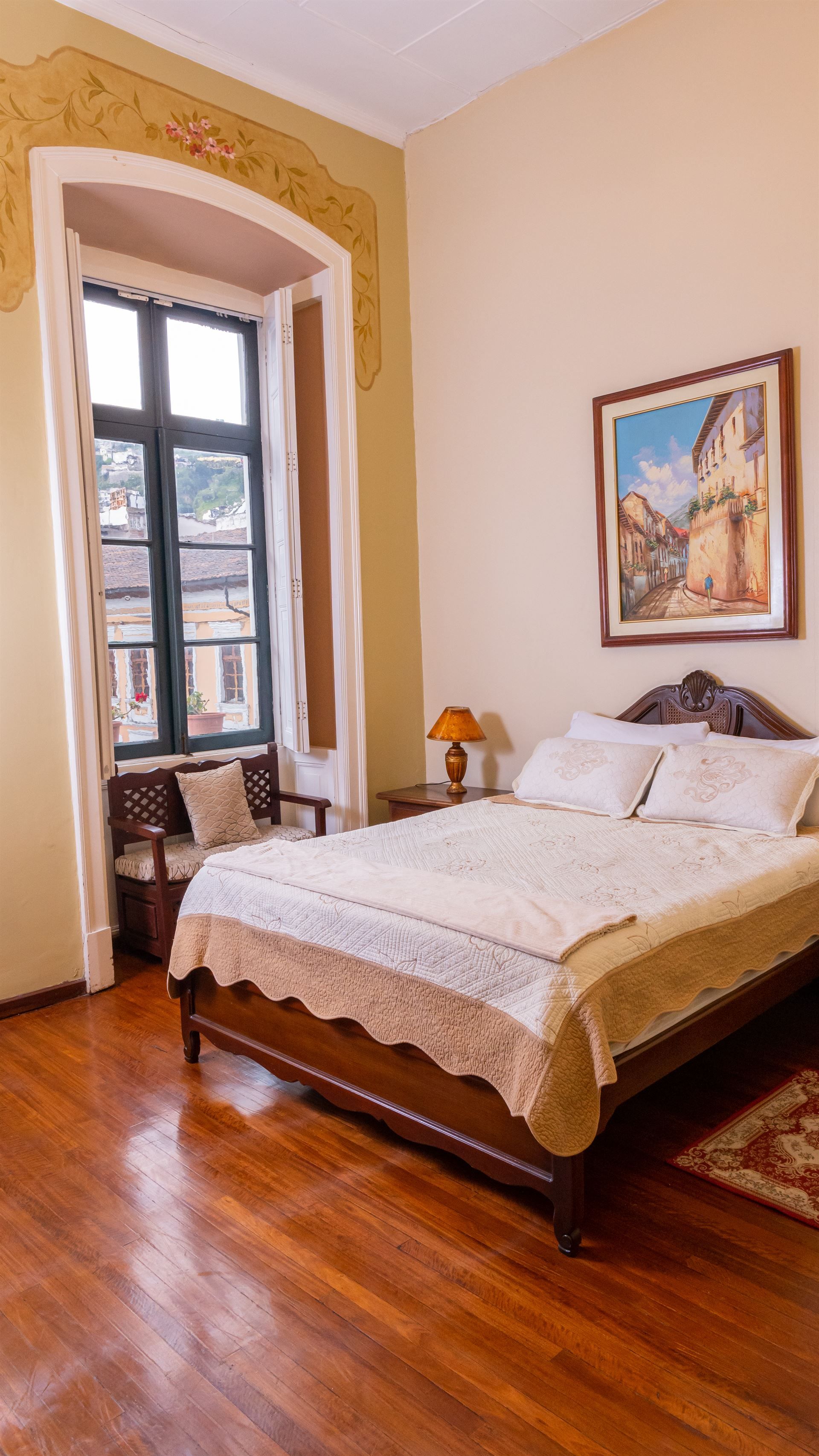 A bedroom with a large bed and a large window.