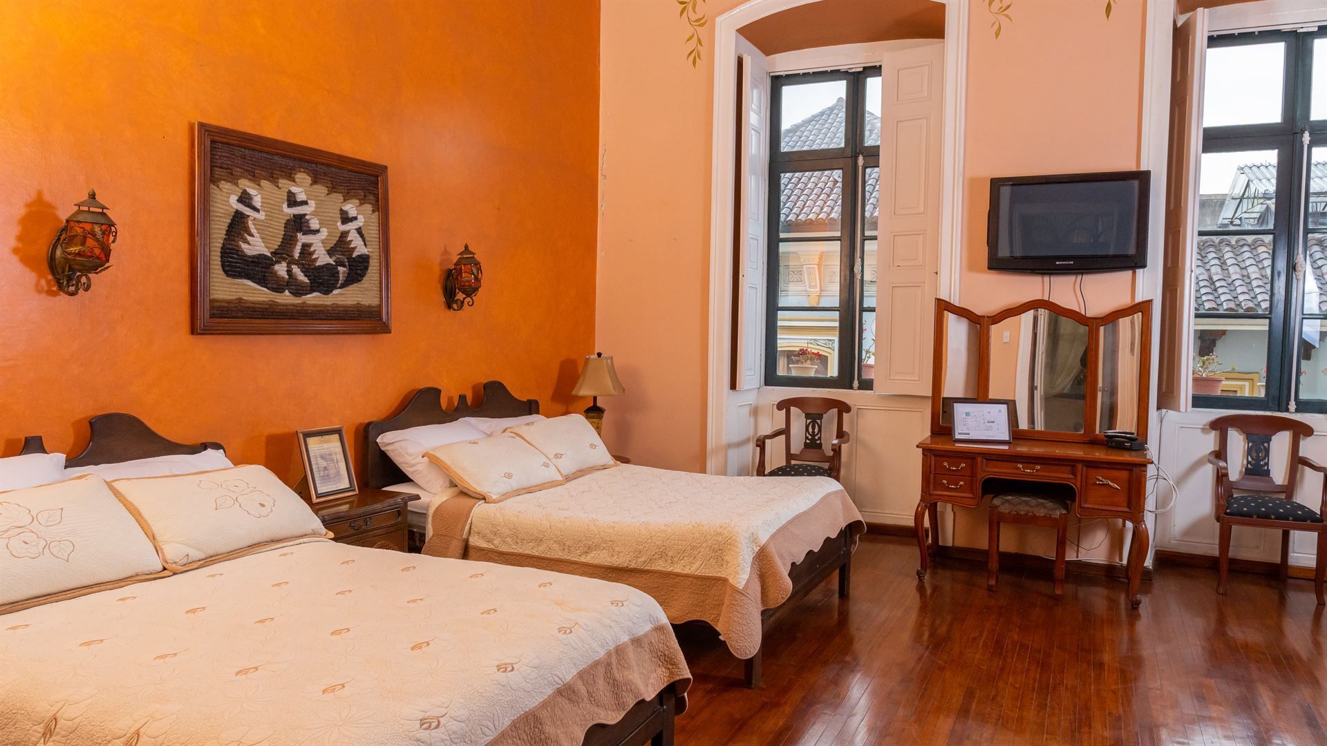 A hotel room with two beds , a desk and a television.