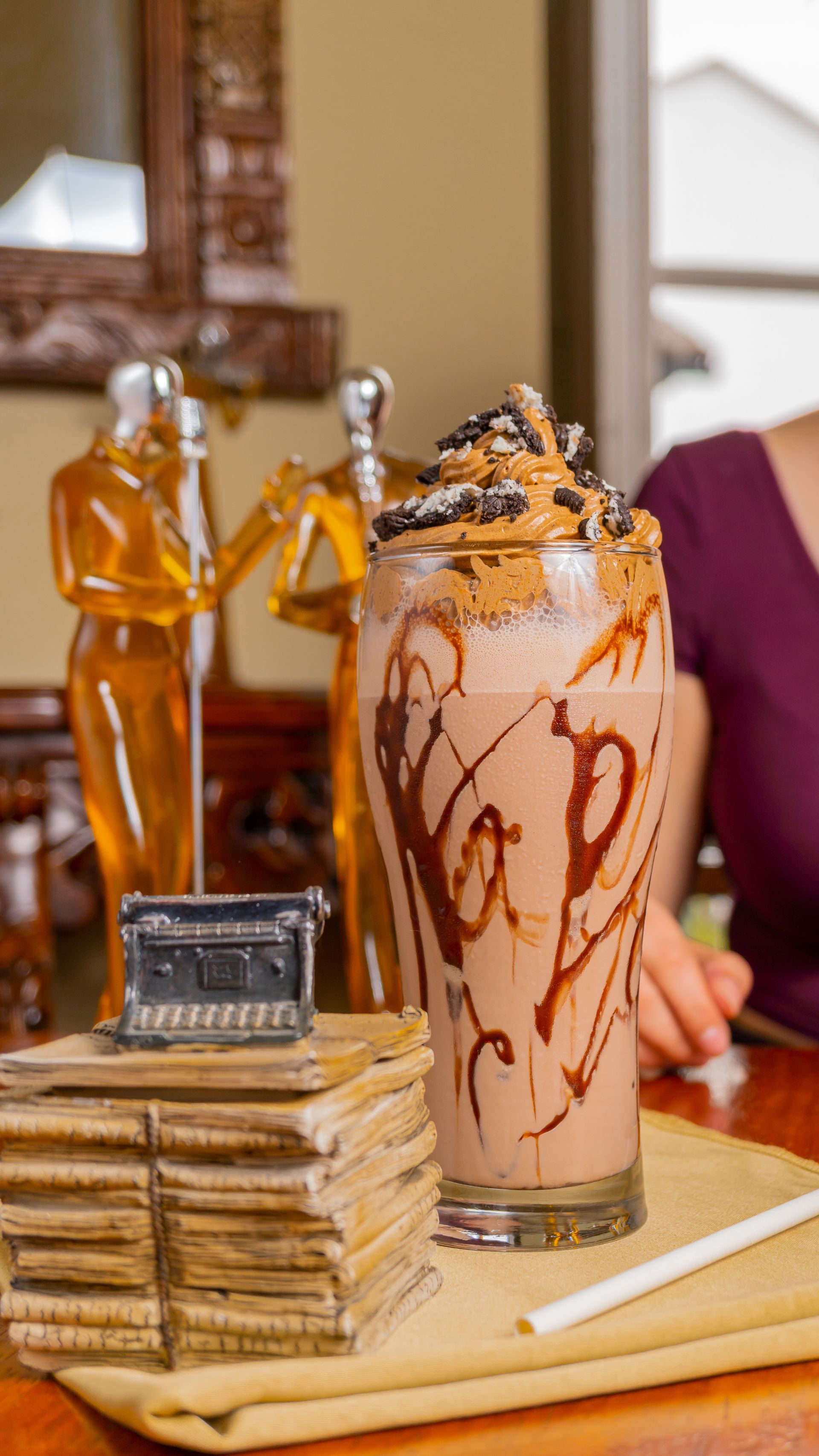 A close up of a milkshake on a table with a straw.