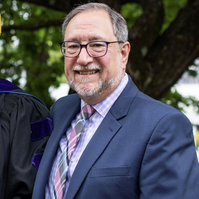 A man in a suit and tie is smiling for the camera