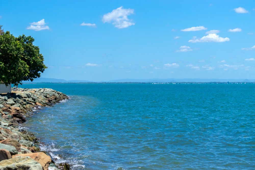 Blue Ocean Meets Rocky Shore Under a Bright Blue Sky — Whirly Bird King in Strathpine, QLD
