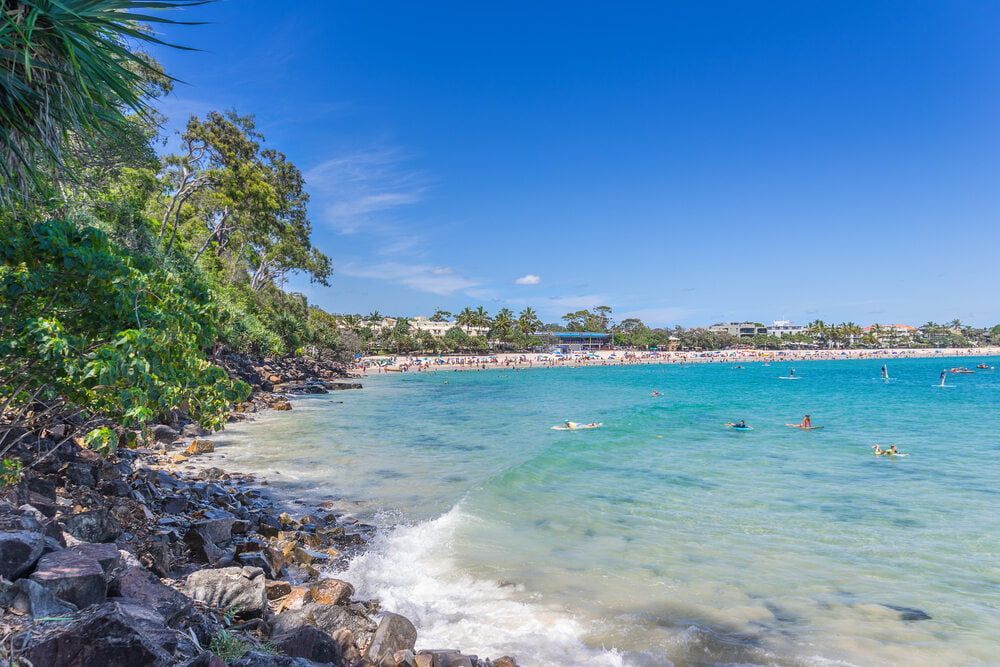 A Group of People Are Swimming in the Ocean on a Sunny Day — Whirly Bird King in Noosa, QLD