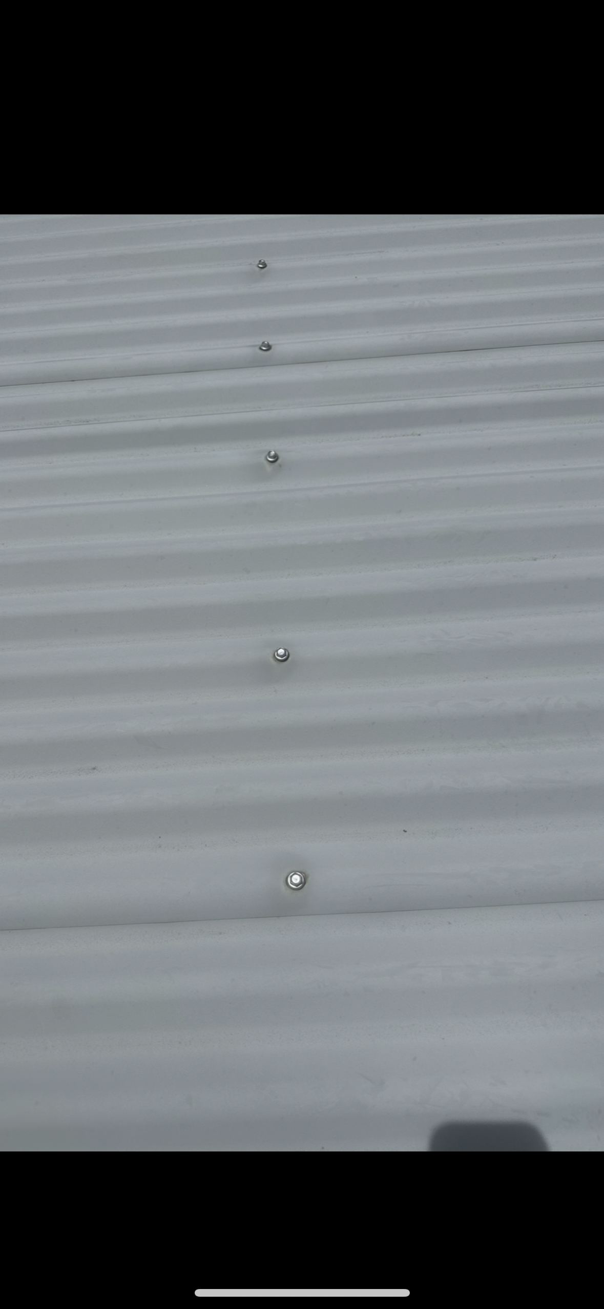 Close-up of a Light-grey Corrugated Metal Roof With a Row of Evenly Spaced Rivets — Whirly Bird King in Brisbane, QLD