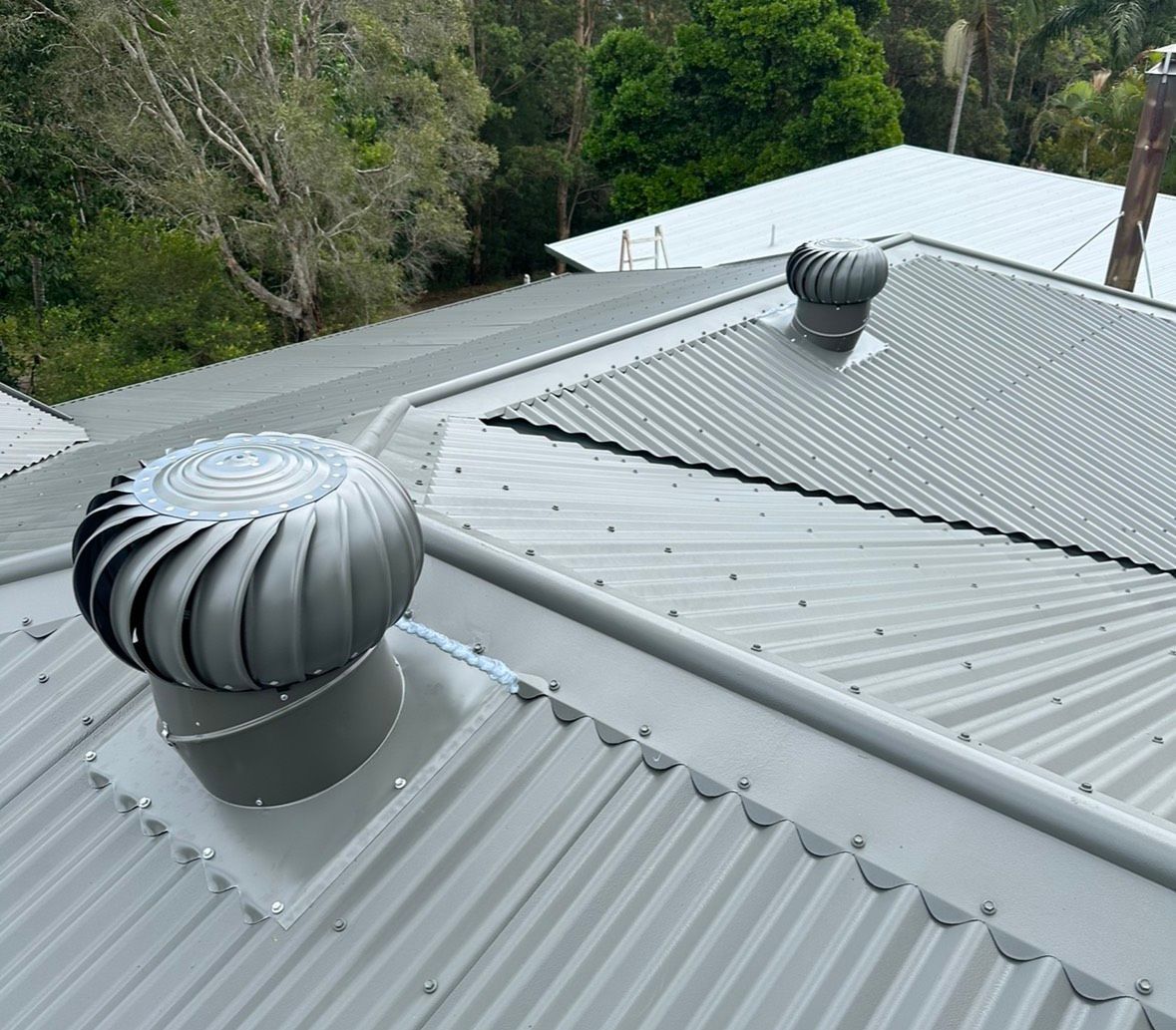 Two Metallic Whirly Bird on a Corrugated Metal Roof — Whirly Bird King in Aspley, QLD
